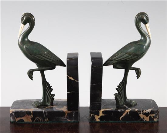 A pair of French Art Deco bronze and ivory stork bookends, 7.5in.